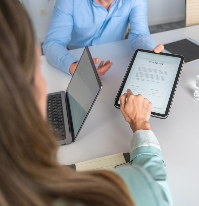 Illustration d'une femme signant un document numérique lors d'une réunion